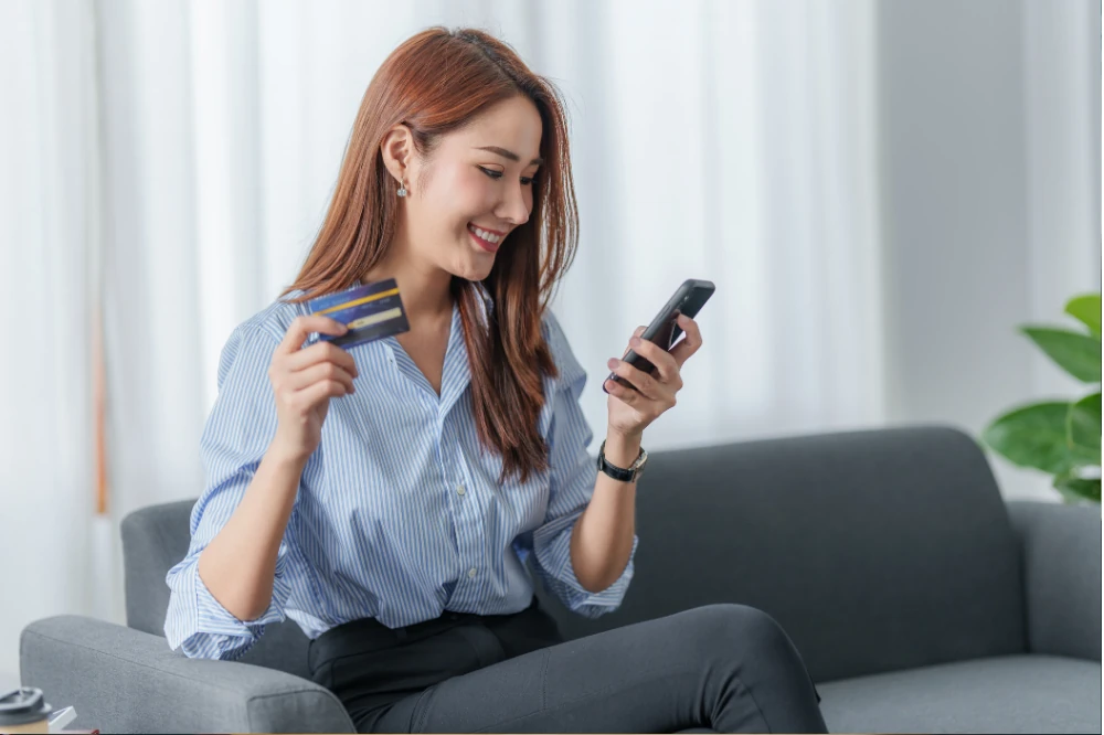 Customer paying with a credit card on a smartphone at home