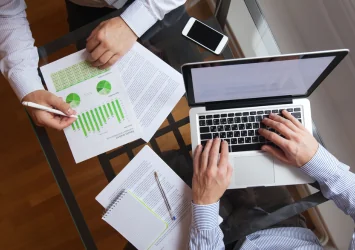 Business owners reviewing financial charts on a laptop